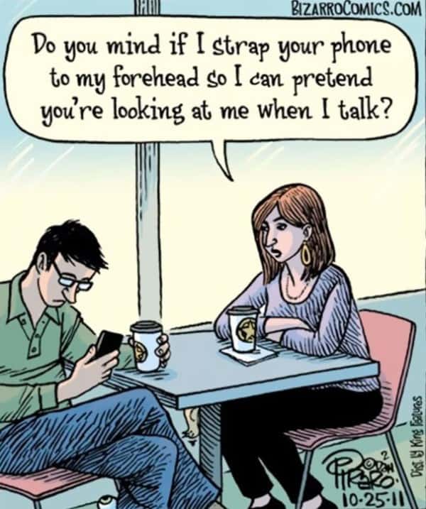 Couple in a coffee shop, one person absorbed in their phone, missing the moment.